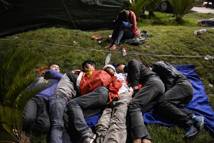 四川雅安蘆山縣，地震后的第一個夜晚，受災群眾躺在草地上睡著了。